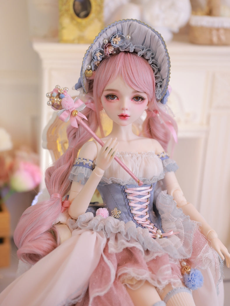 Carla Doll by Sukuroi holding a wand, wearing a pink and blue dress with floral details