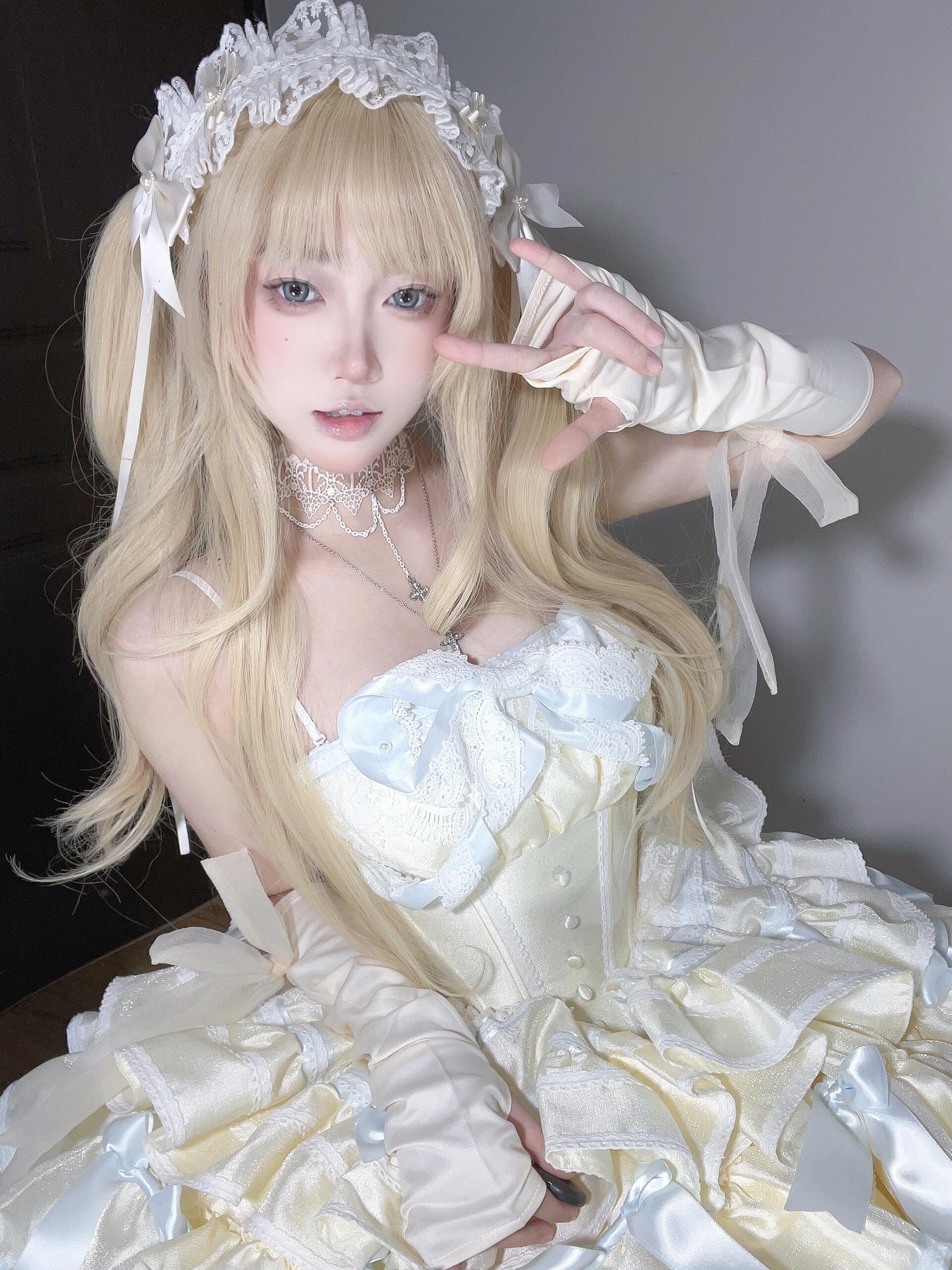 Close-up of a model wearing a Short Off Shoulder Lolita Dress with a white lace-up corset and pastel detailing