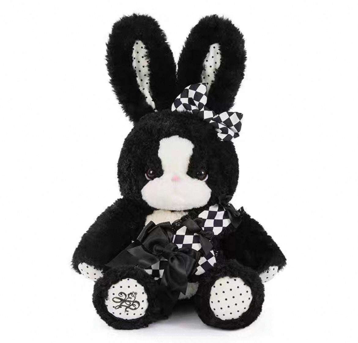 Close-up of a black and white plush bunny with checkered bows
