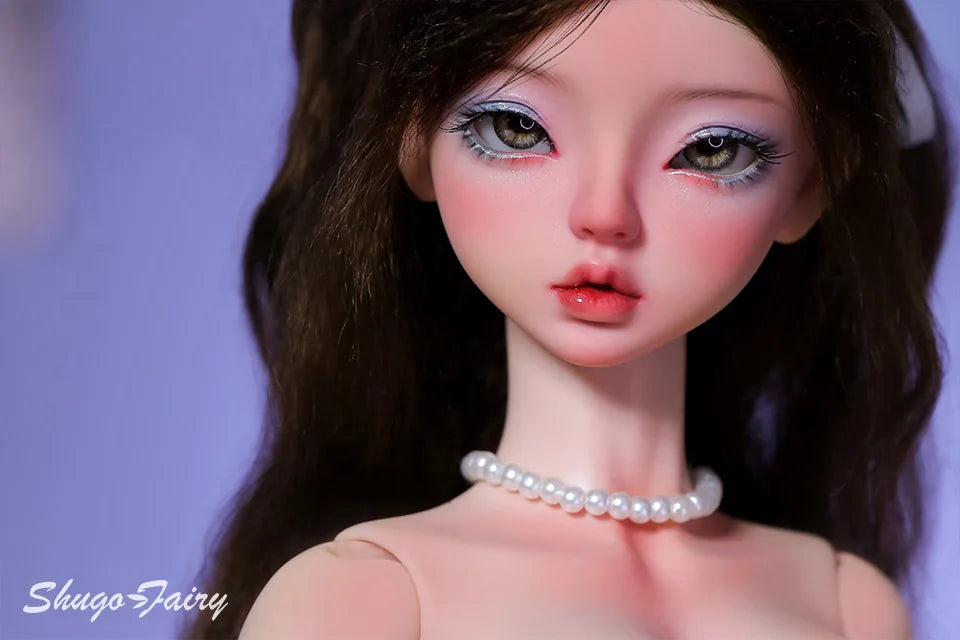 Doll wearing a white floral dress with orange flowers and a pearl necklace close up view