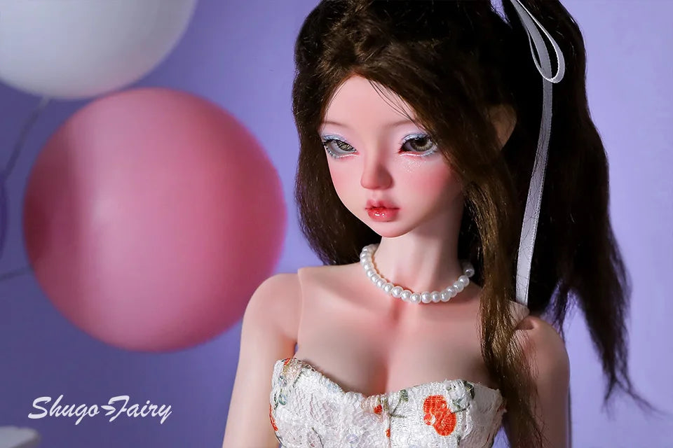 Doll wearing a white Doll Floral Dress with orange flowers and pearl necklace