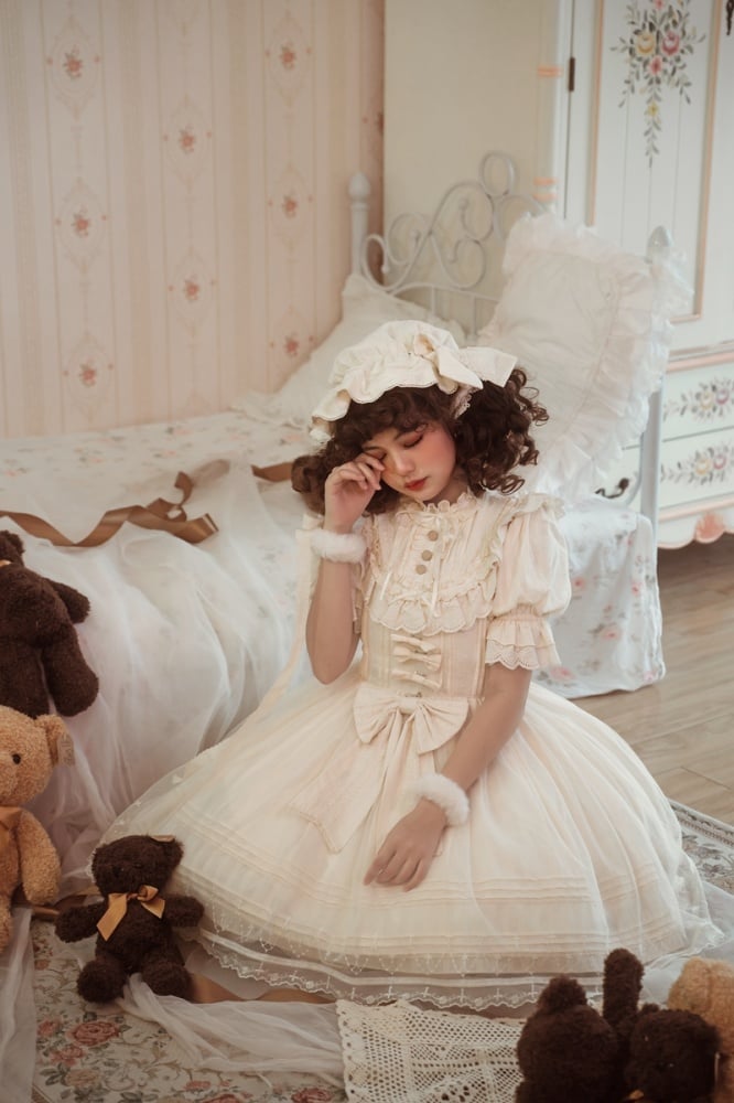 Lolita Fashion style in a delicate cream dress, with curls and a bonnet from Sukuroi