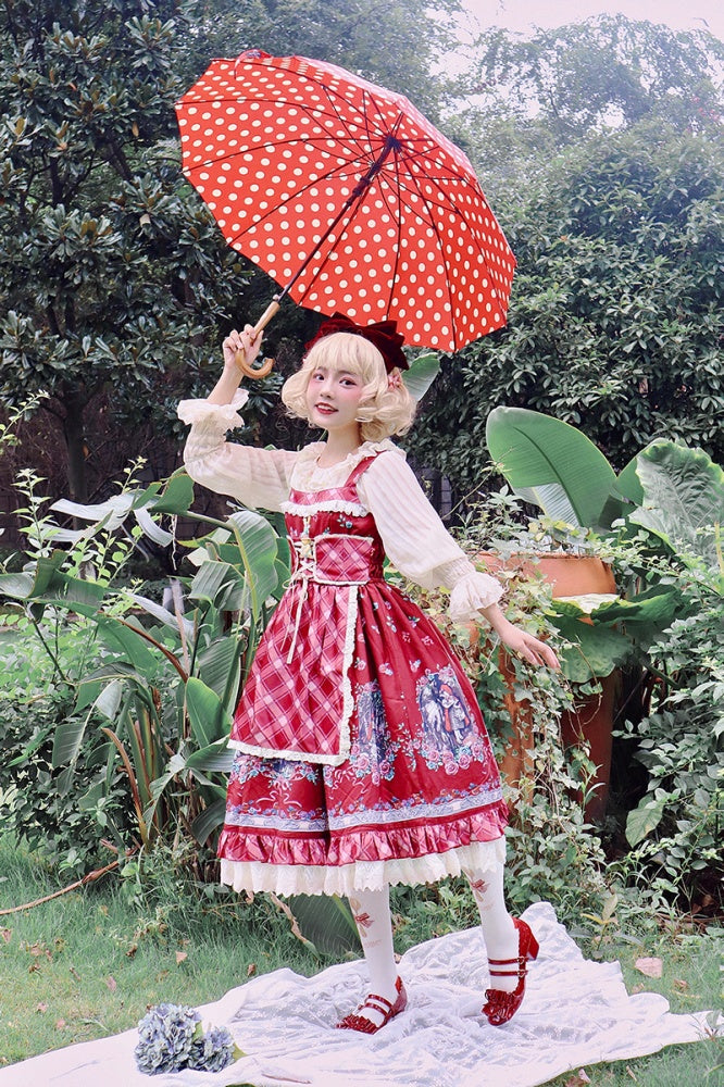 Model holding red polka-dot umbrella while wearing Little Red Riding Hood jumper skirt in garden