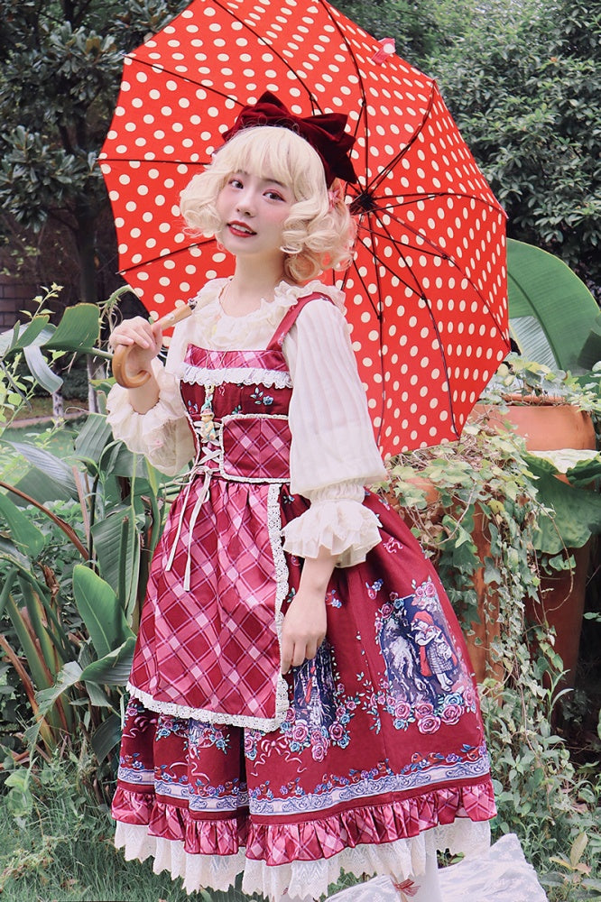Model in Little Red Riding Hood jumper skirt with red polka dot umbrella in garden