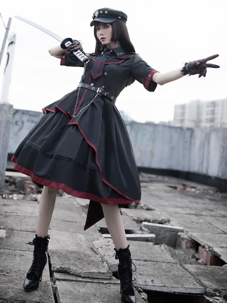 Model in Gothic military-inspired black dress striking sword pose