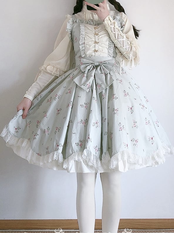 Model in light green jumper skirt with lace edges and a bow