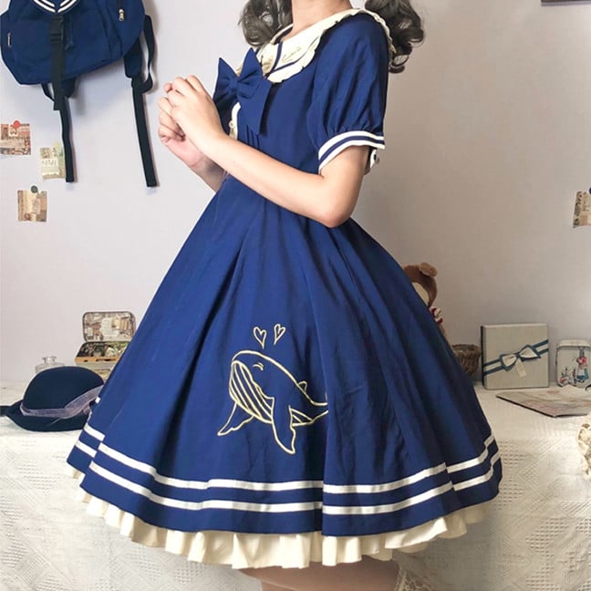 Model in dark blue dress with whale embroidery