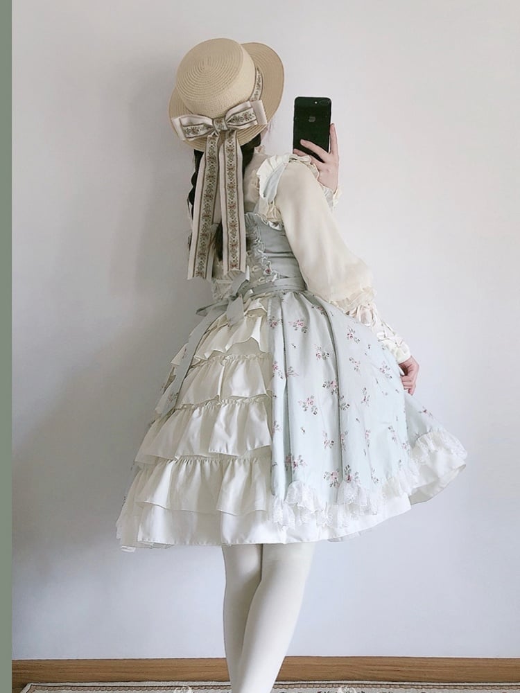 Back view of a model in a light green floral jumper skirt