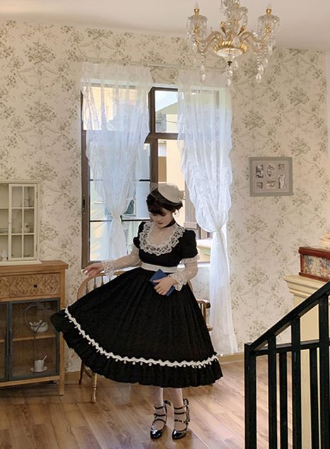 Elegant black one piece with flounce hem, long sleeves, and vintage neckline detail