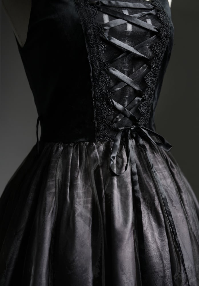 Close-up of black jumper skirt styled with gothic candle
