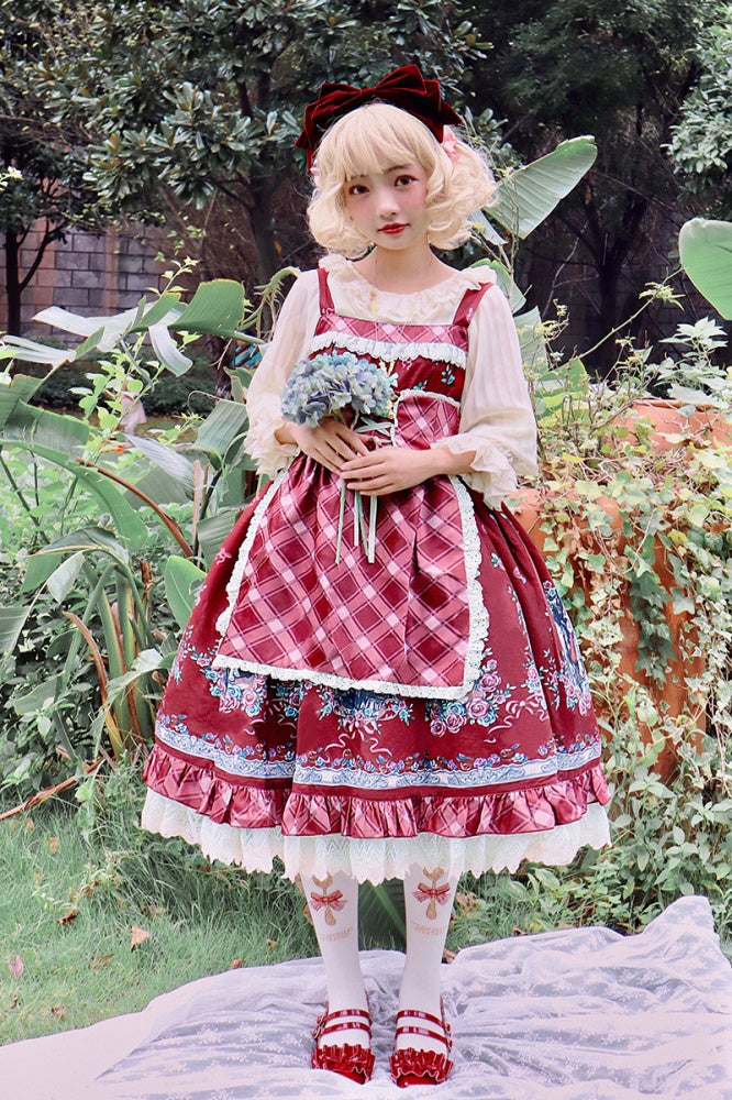 Model wearing Little Red Riding Hood jumper skirt in red with apron and floral details
