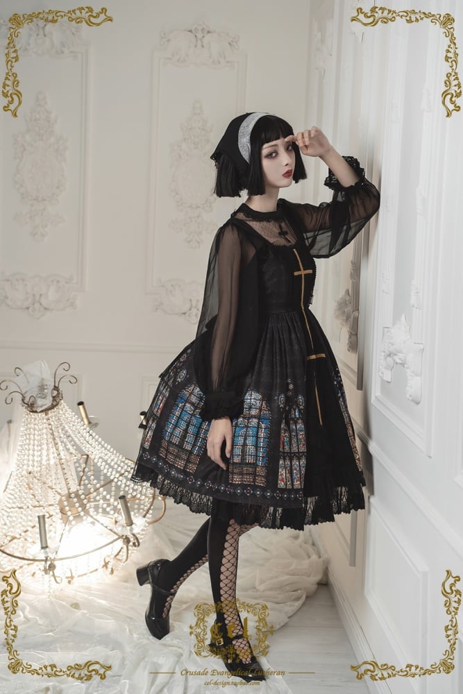 Model in black dress with sheer sleeves and stained glass details