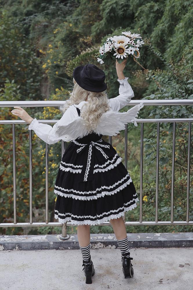 Black Cake Tree Tiered Flounce Skirt with white lace detailing, paired with angel wings and a floral bouquet