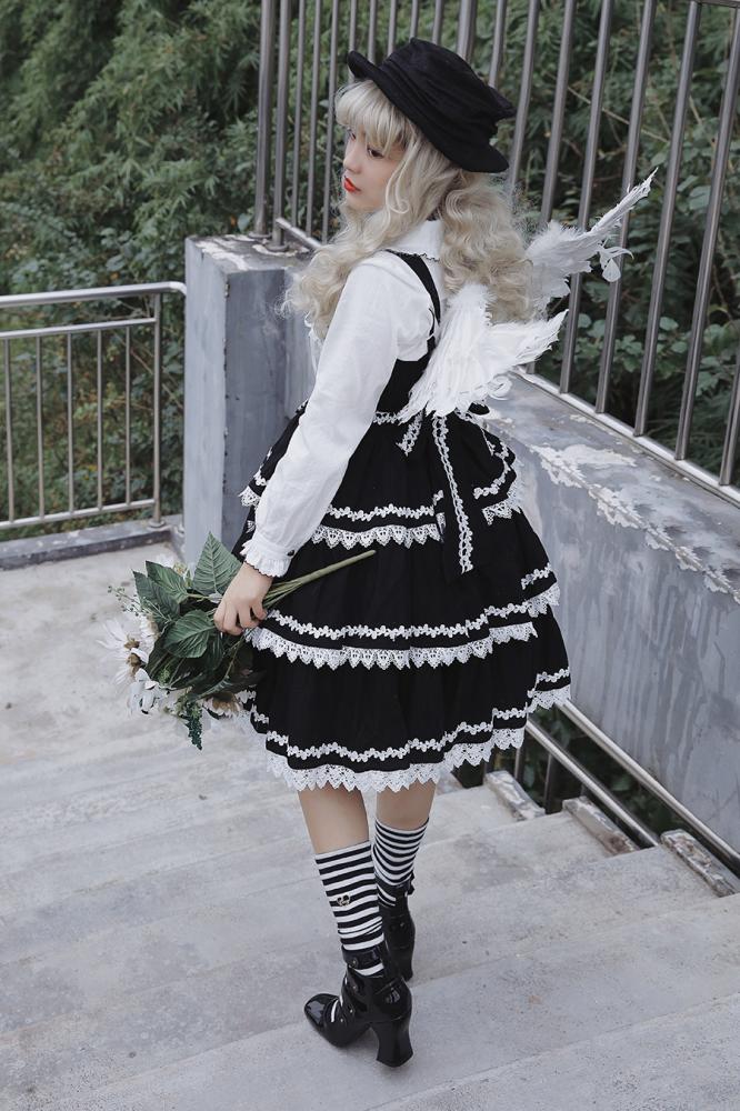 Black Cake Tree Tiered Flounce Skirt paired with a white blouse and striped socks, styled in a whimsical outdoor setting